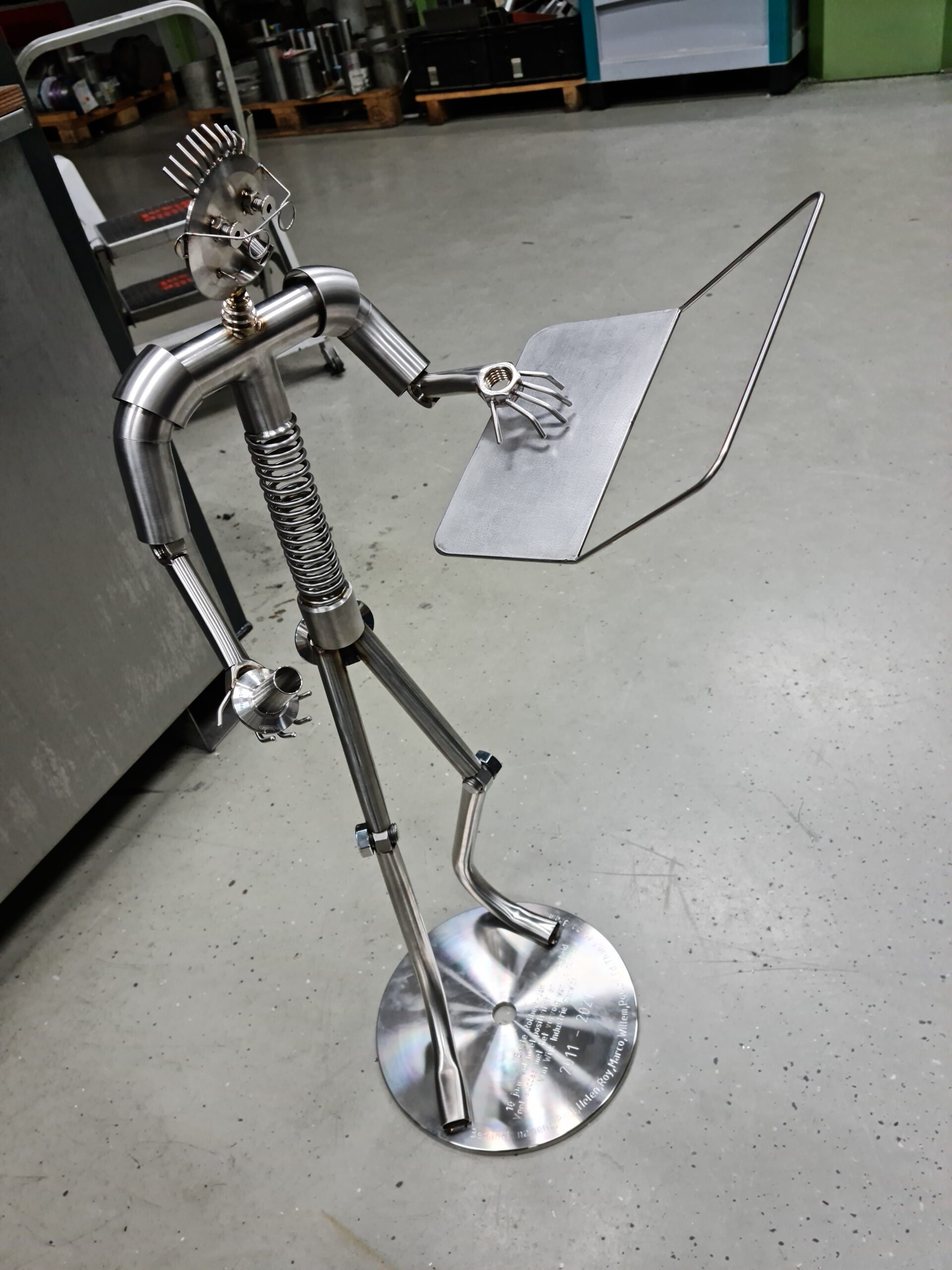 groot metalen mannetje die computer vasthoud