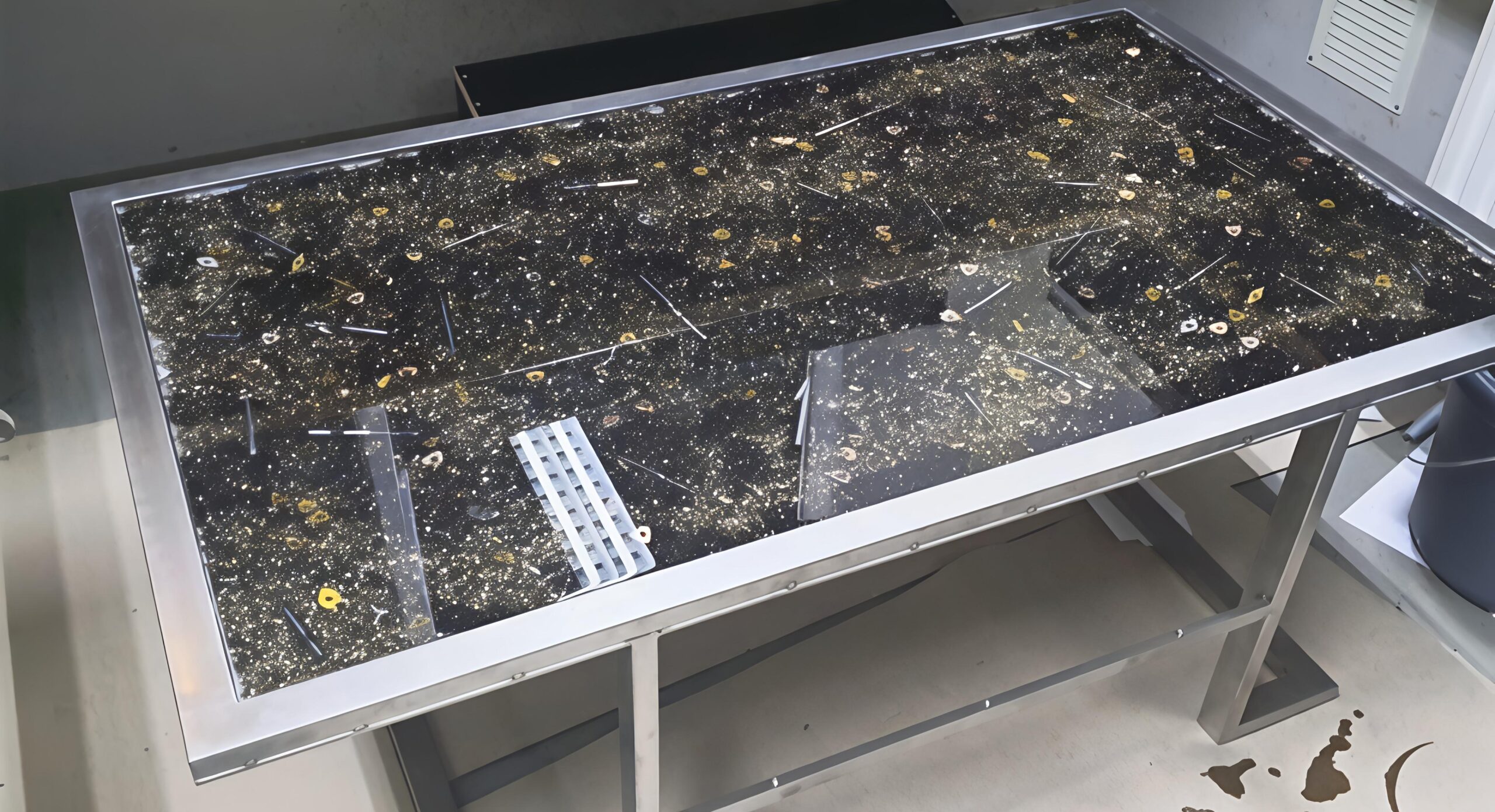 gegoten epoxy tafel gemaakt van RVS met metalen onderdelen.